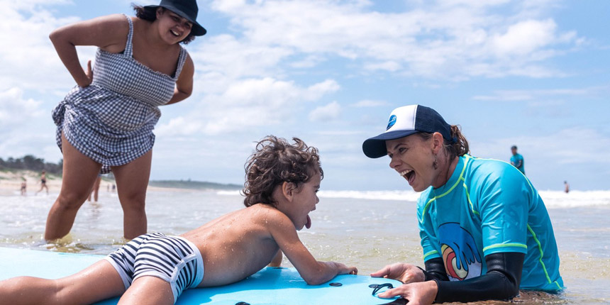 Aimee in the surf with a young boy