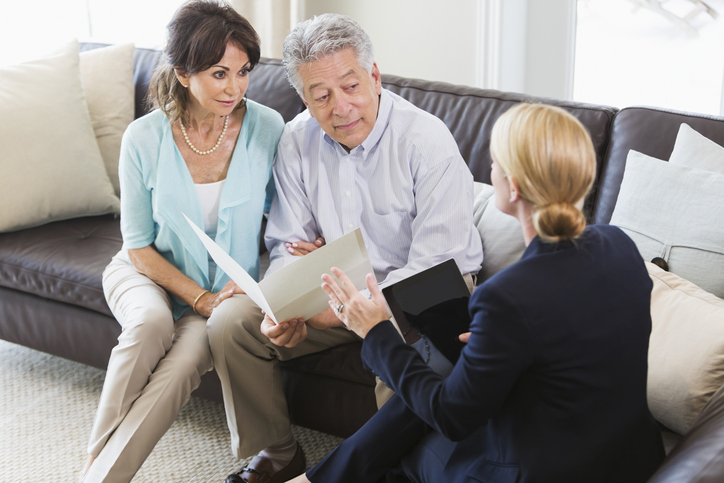 A senior couple getting ultra-high net worth wealth management from a financial advisor.